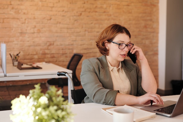 person%20sitting%20at%20their%20desk%20talking%20on%20their%20phone